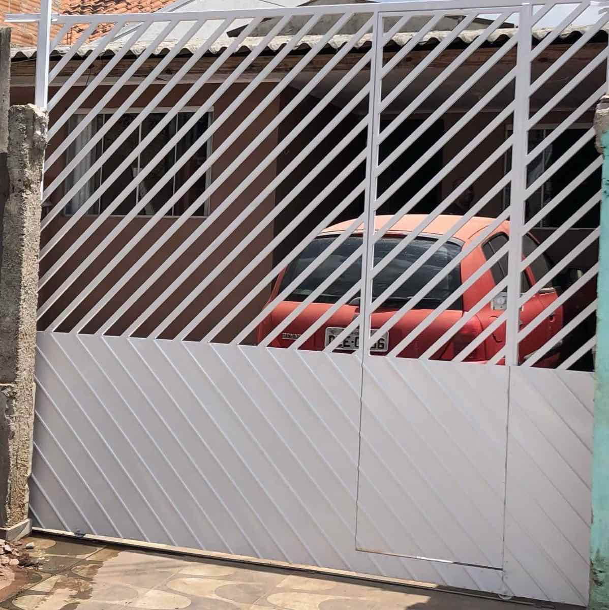 Portão residencial branco em estrutura metálica instalado em garagem